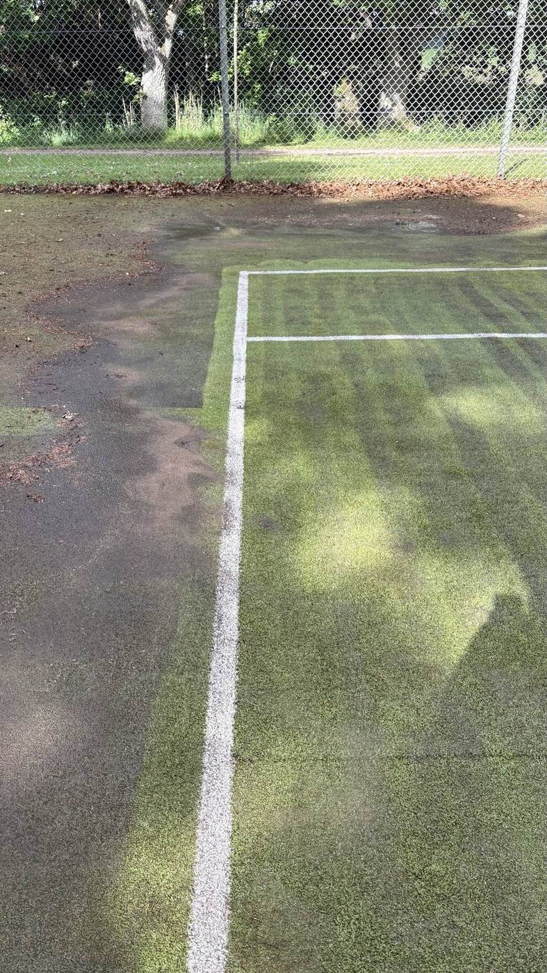 Tennisbane halvt renset — sort til venstre, ren grøn til højre